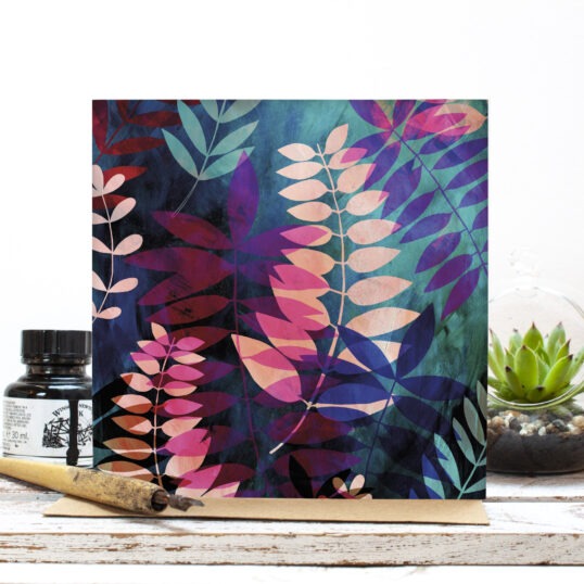 Greetings card featuring bold colourful layered palm leaves in pink, blue and green.